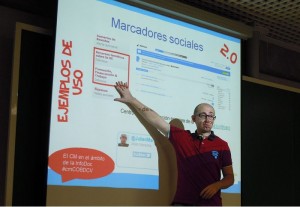 Foto de Julián Marquina señalando a la proyección de su presentación